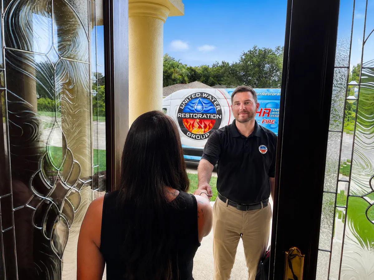 United Water Restoration Group technician greeted at a homeowner's front door